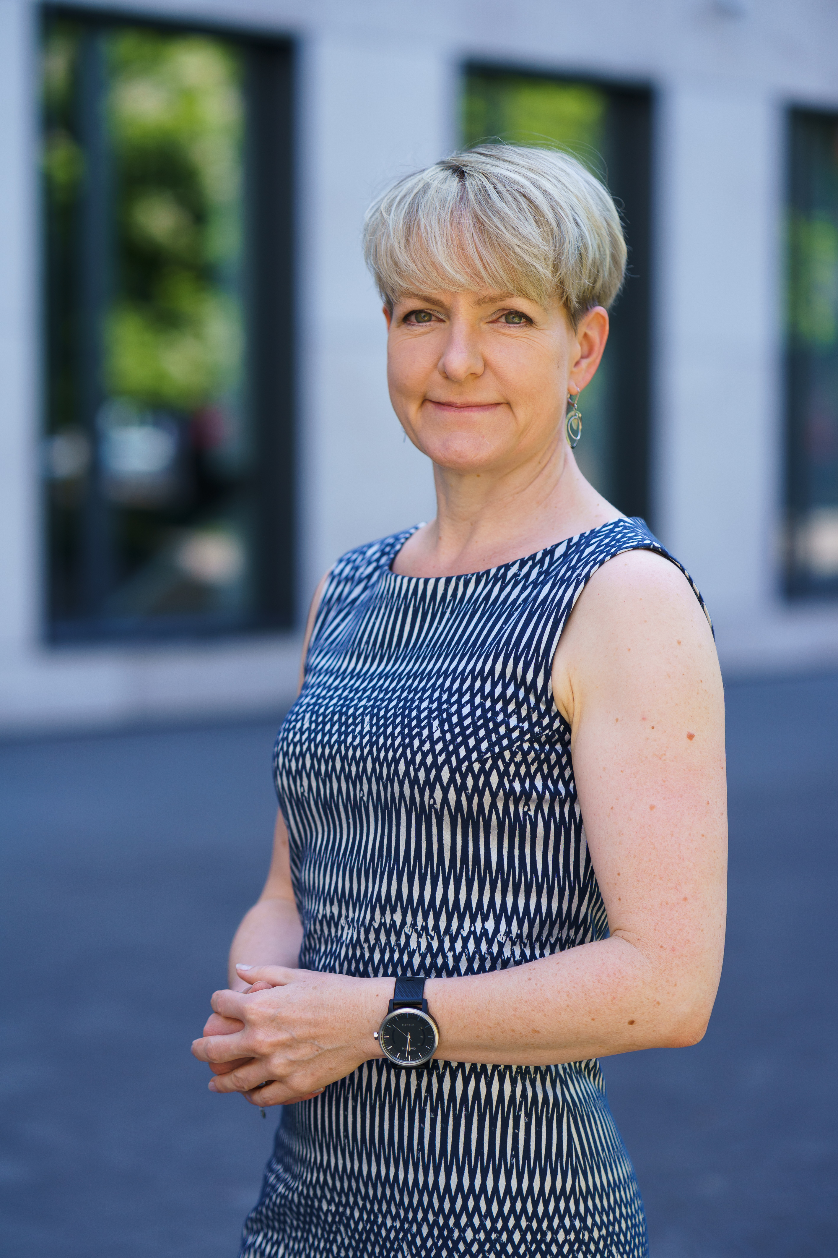 Professionelles Porträt einer Frau vor modernem Bürogebäude