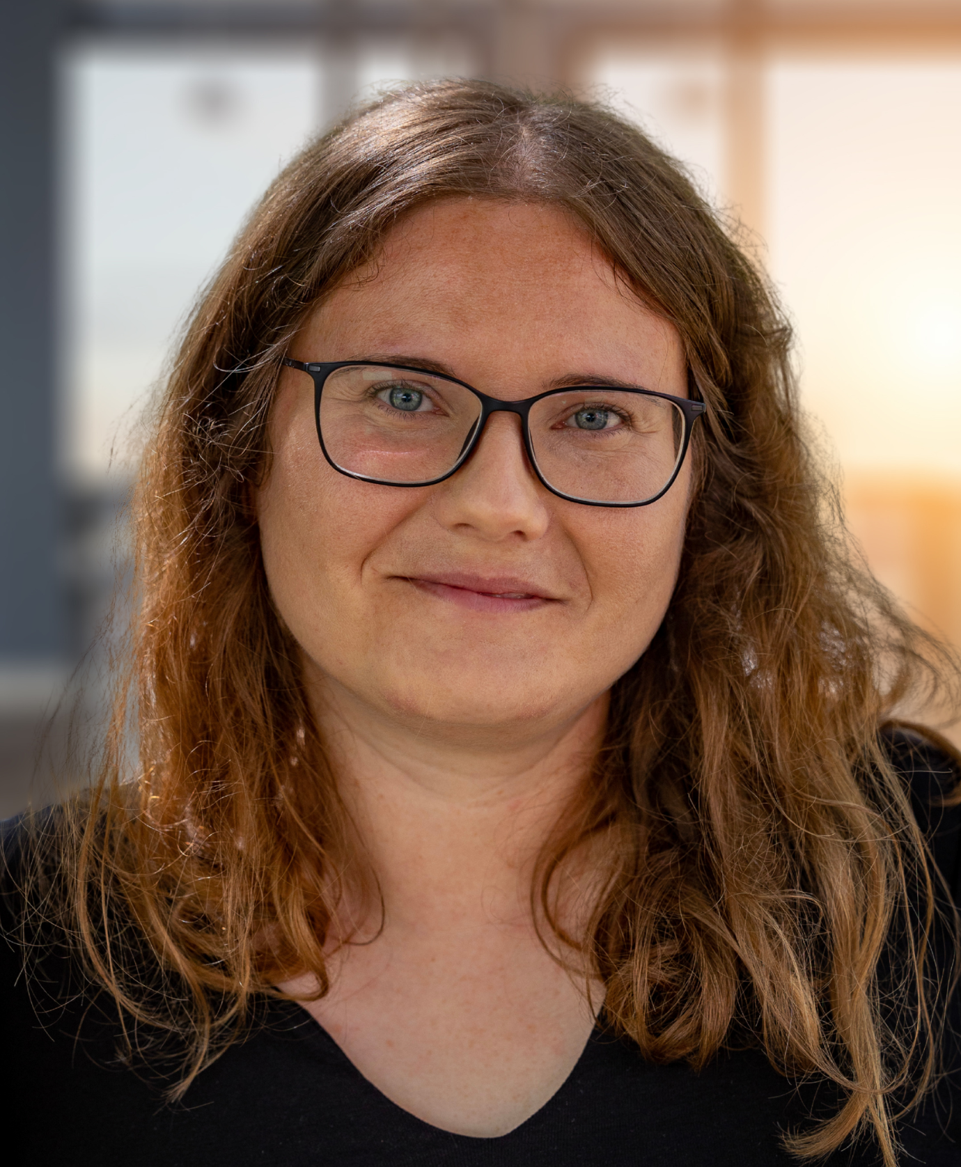 Professionelles Porträt einer Frau mit Brille im Büro