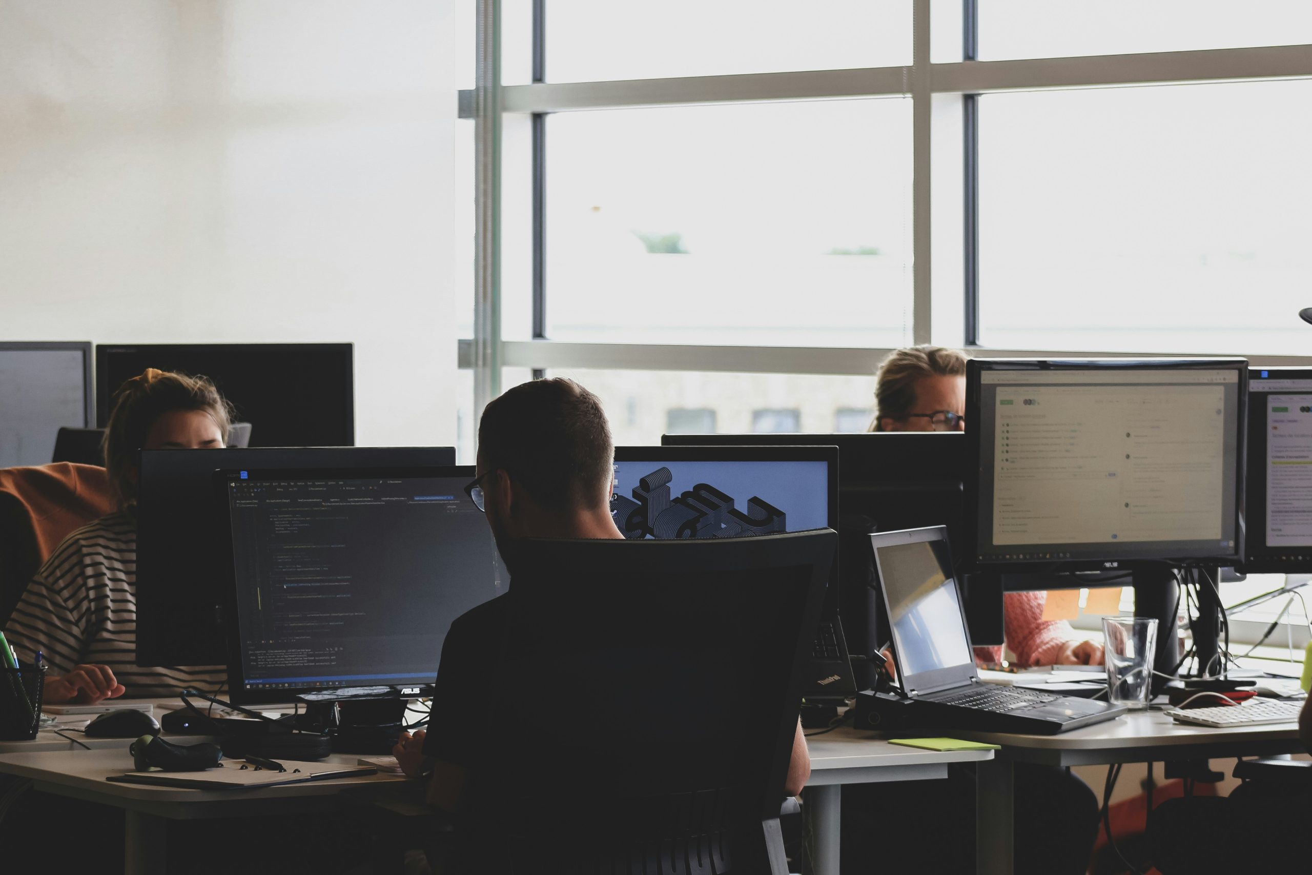Softwareentwickler arbeiten konzentriert an ihren Computern im modernen Büro
